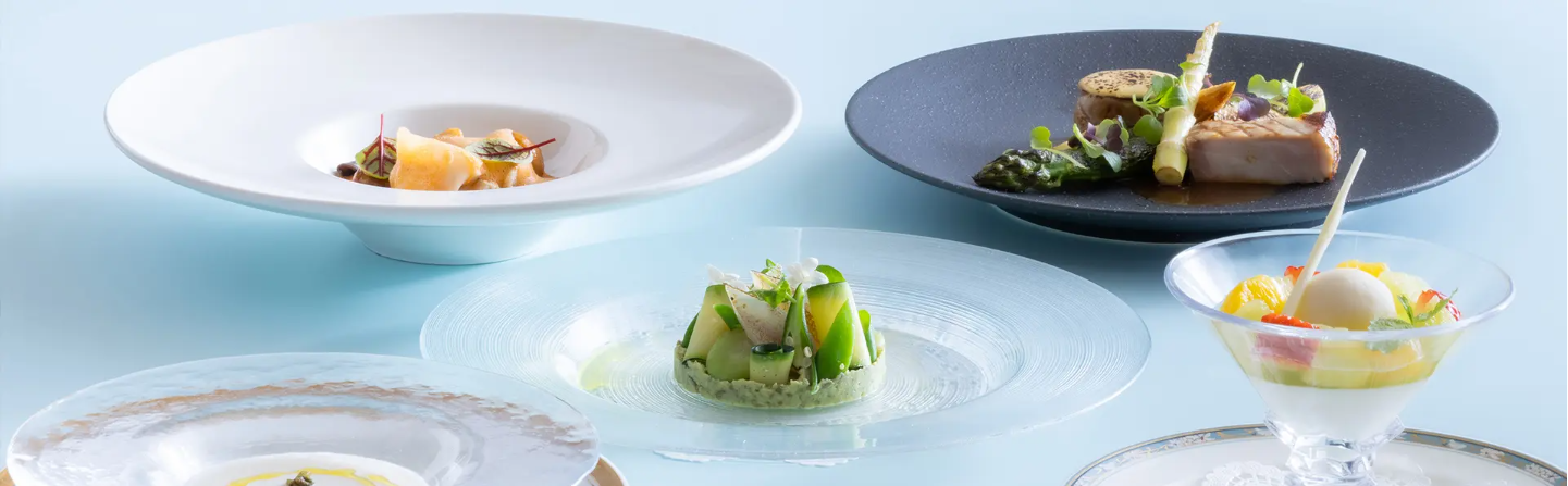 美しく盛り付けられたフランス料理のコースです。各皿には色とりどりの前菜、メインディッシュ、デザートが並べられており、洗練されたプレゼンテーションが特徴です。