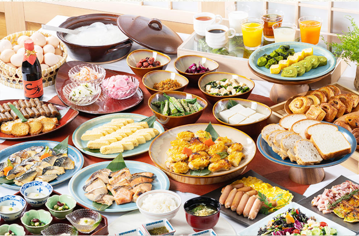 豊富な種類の朝食ビュッフェです。パン、卵、サラダ、ジュース、コーヒーなどが並び、色とりどりの料理がテーブルに広がっています。