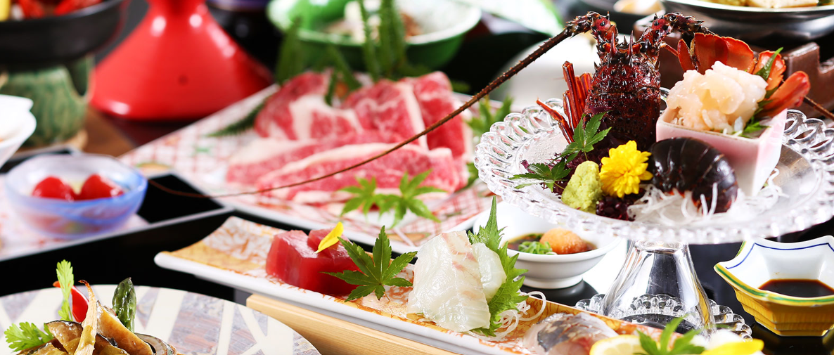 豪華な和食の料理です。刺身や肉料理が美しく盛り付けられた皿がテーブルに並んでいます。色とりどりの食材が目を引きます。