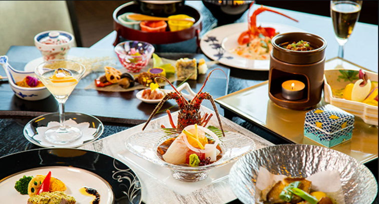 豪華な和食のコース料理。新鮮な海の幸を使った料理が並び、色とりどりの食器が使用されている。刺身や煮物、デザートなどが美しく盛り付けられている。